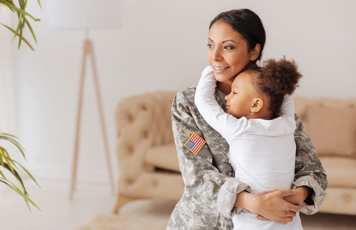 Military mom holding child