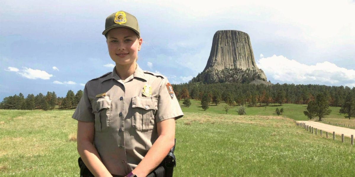 park ranger standing in front of Devil's Tower in Wyoming