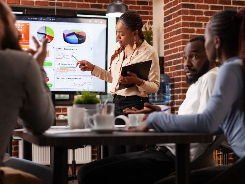 African american manager showing marketing presentation explaining company strategy planning business partnership working in startup office