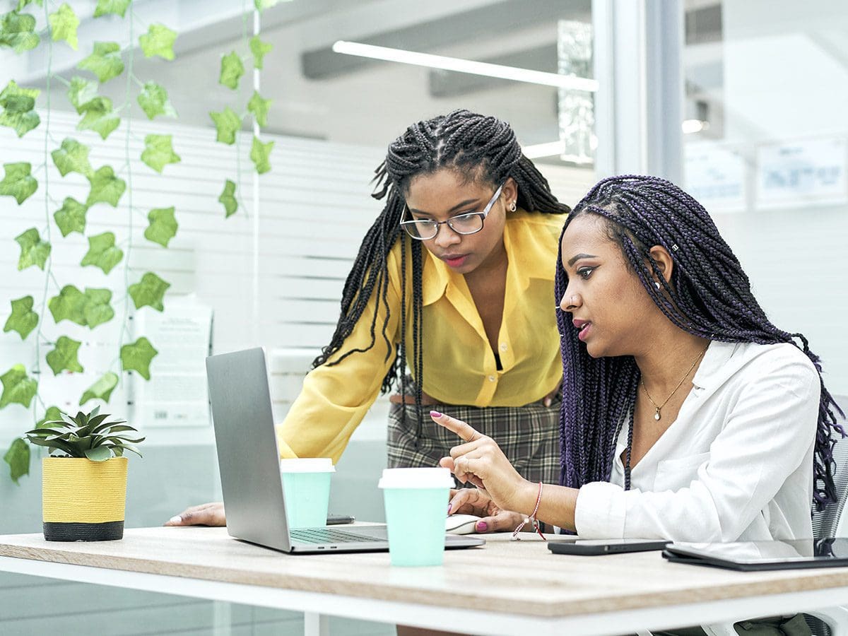 two woman reviewing data at a computer