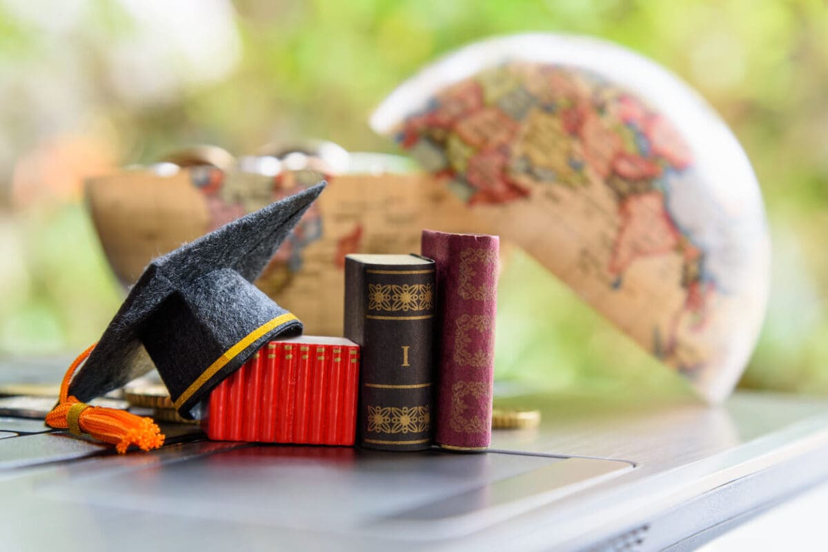 a halved glove with books and a graduation hat