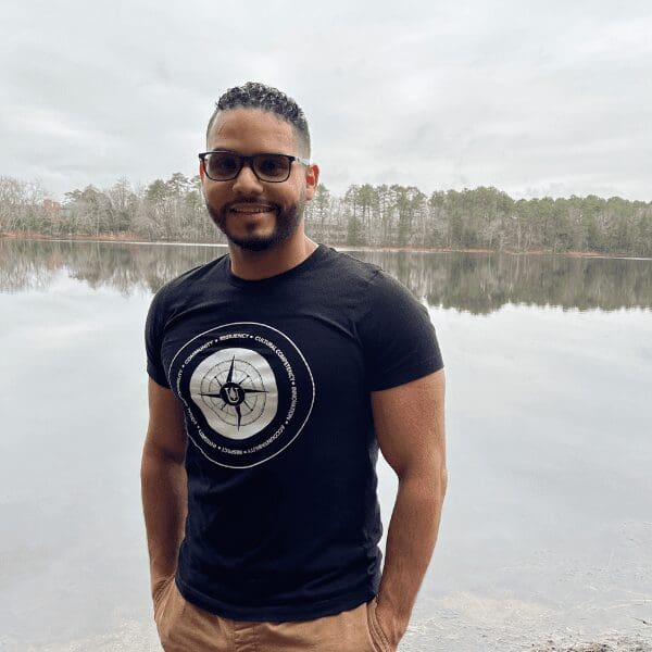 DE Ambassador Javier stands in front of a lake.