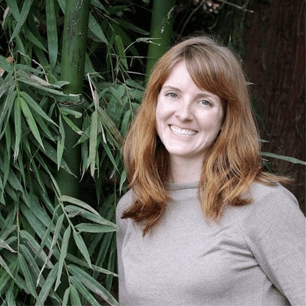 Dr. Meghan Martin, one of Unity's new academic hires, smiles at the camera in front of a bamboo forest.
