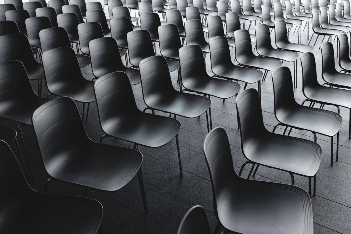 a university classroom filled with empty black chairs