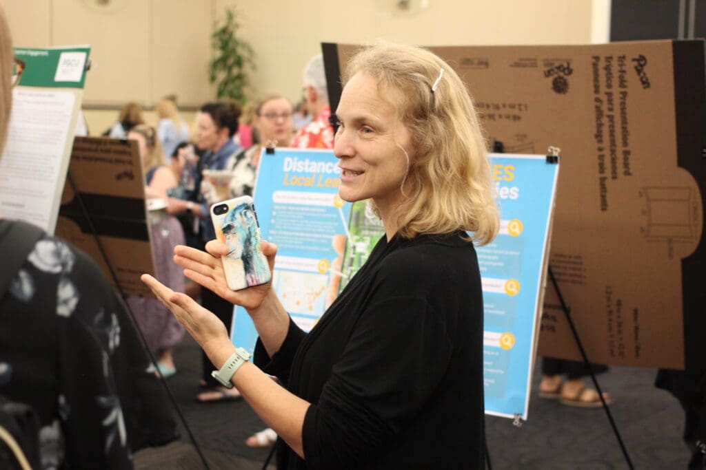 Dr. Kelly Boyer Ontl explains her presentation in front of a colorful poster that outlines her stance on AI.