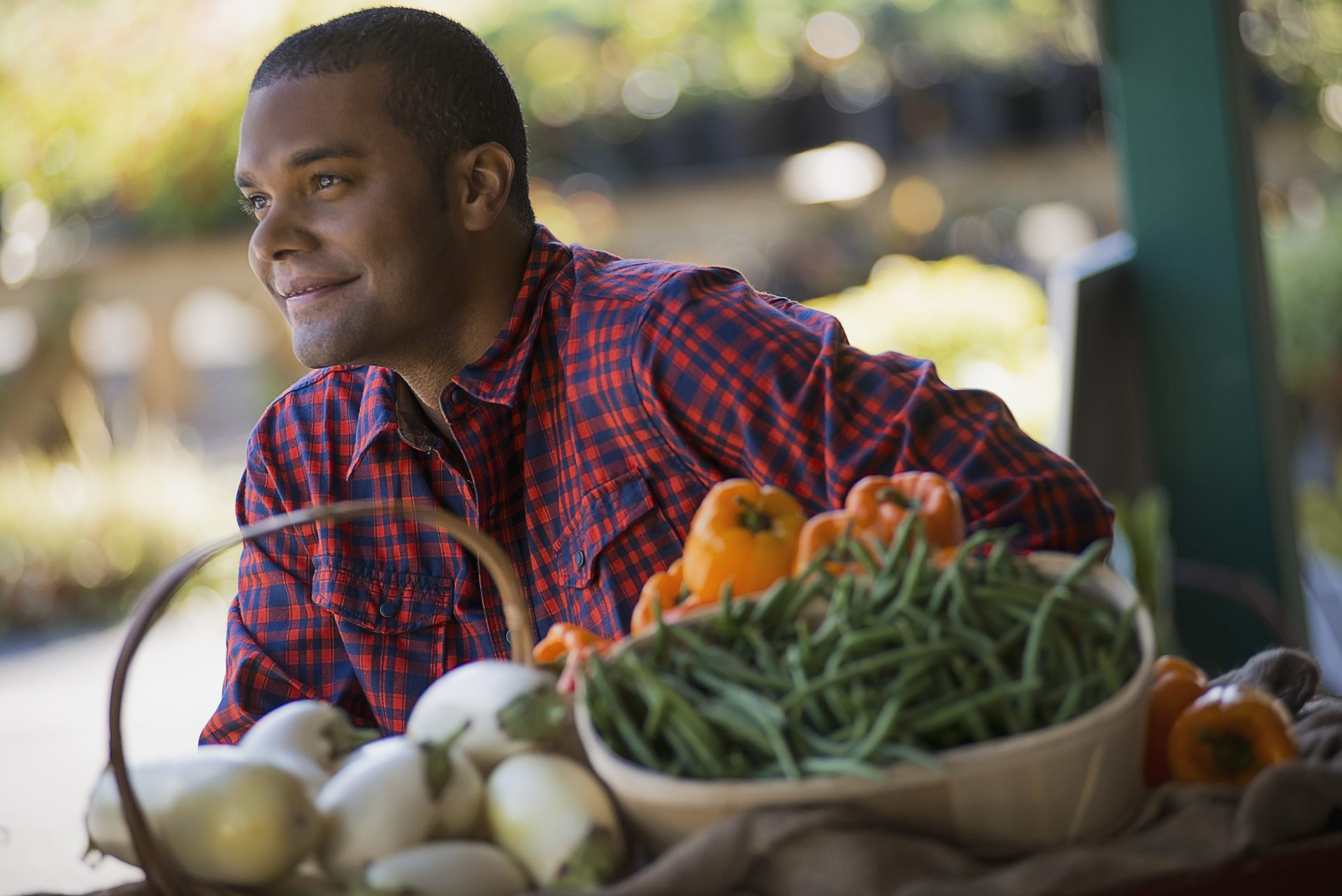 A farmer with a tray of freshly harvested produce.