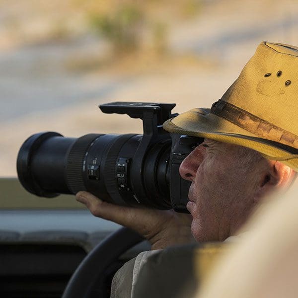 A man wearing a bush hat taking a photo.