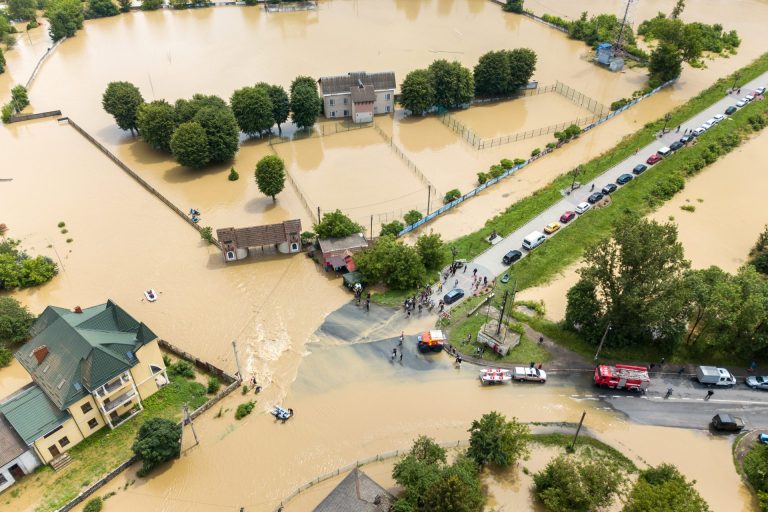 Aerial view of flooded houses and rescue vehicles.