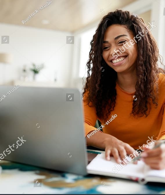 distance-education-portrait-of-smiling-woman-sitting-at-desk-using-laptop-and-writing-in-notebook (2)