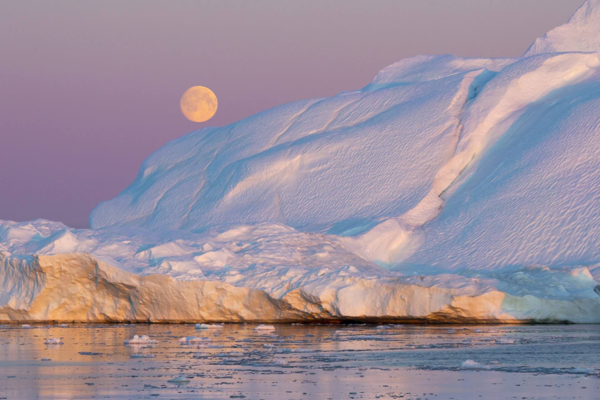 Golden iceberg against a full moon.