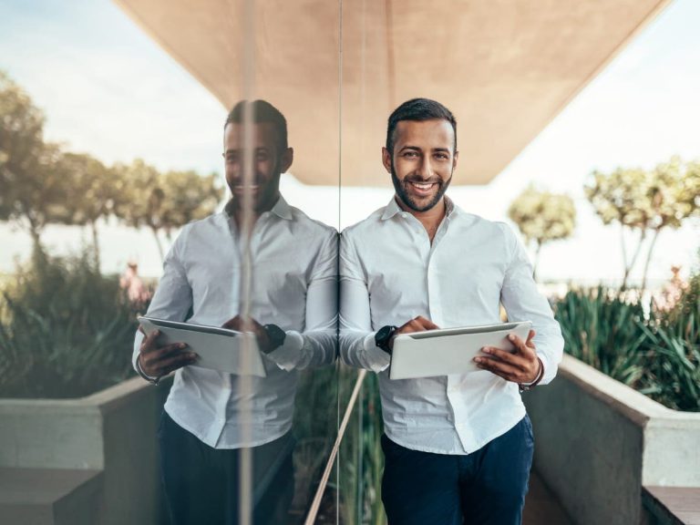 indian-businessman-standing-outside-building-with-a-tablet-picture-id1096035156