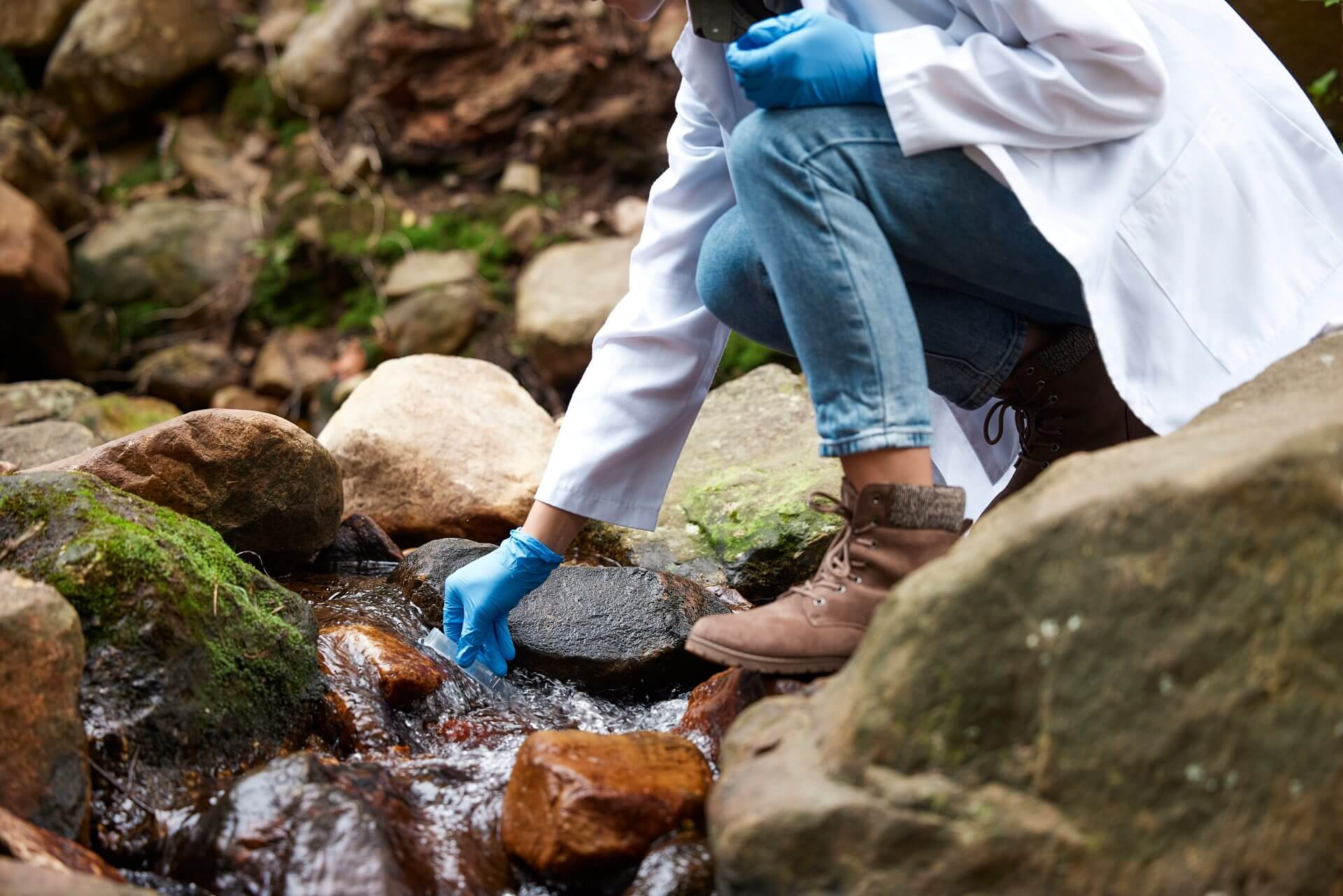 Woman testing river water using a test tube.