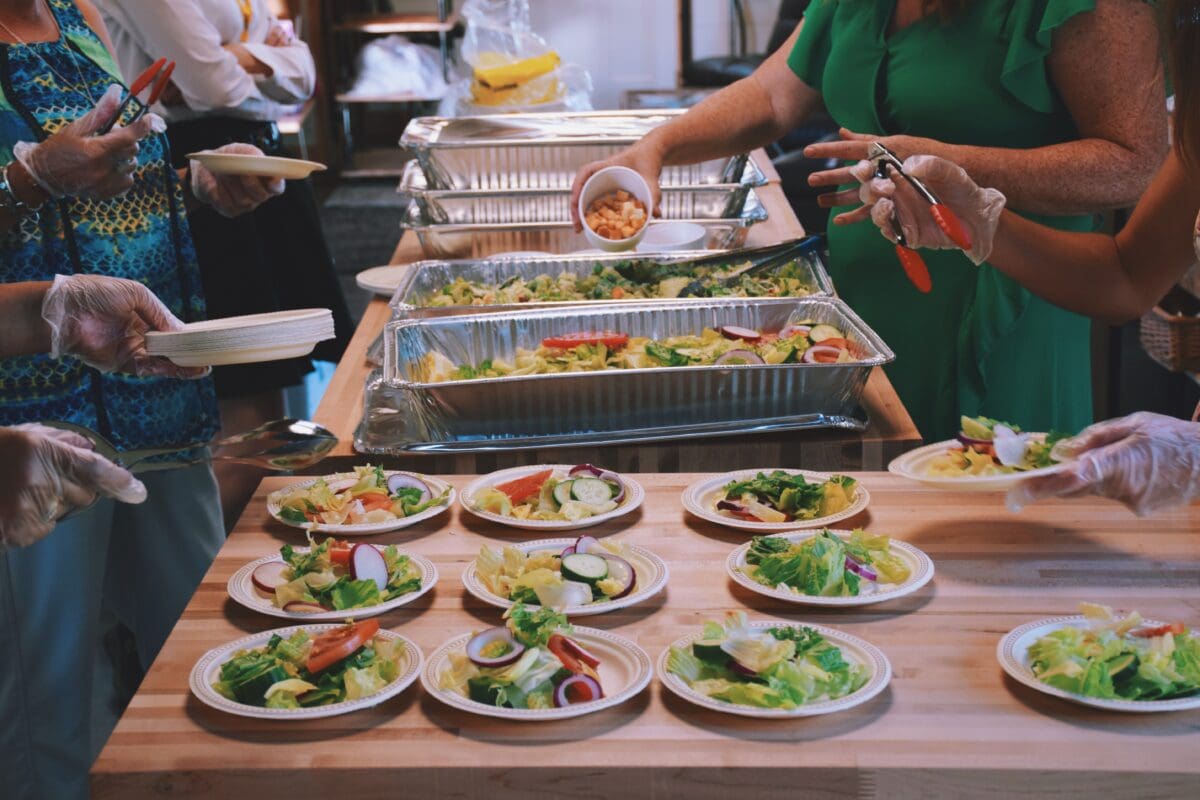 women-volunteers-filling-up-plates-with-food-at-a-2023-11-27-05-19-02-utc-scaled
