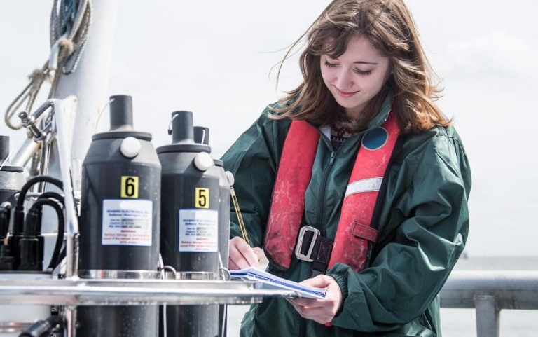 153467120_female-scientist-making-notes-with-sea-water-sampl-2023-11-27-05-08-59-utc-fewat-thumbnail-scaled