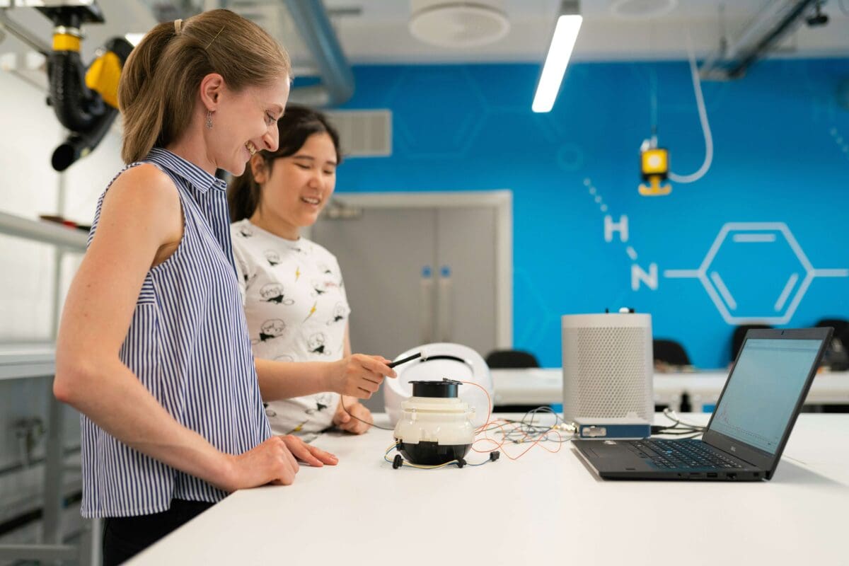 two people in a lab doing hands on learning with a robot