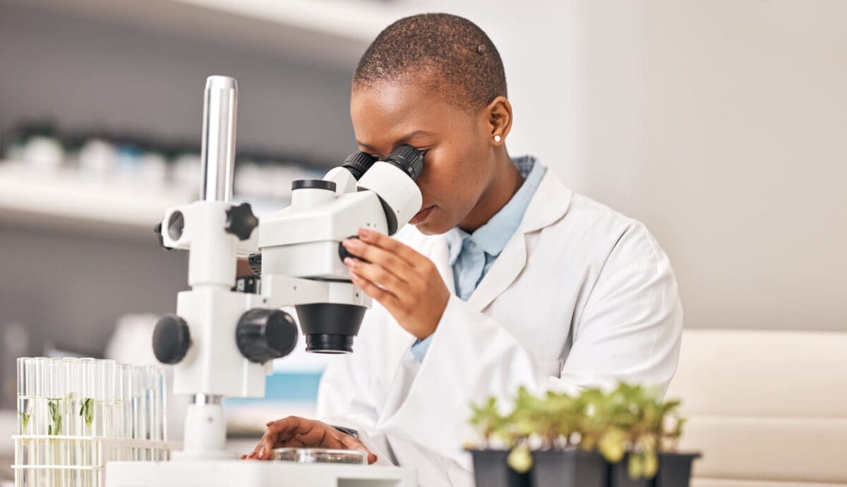 a scientist using a microscope to study biodiversity