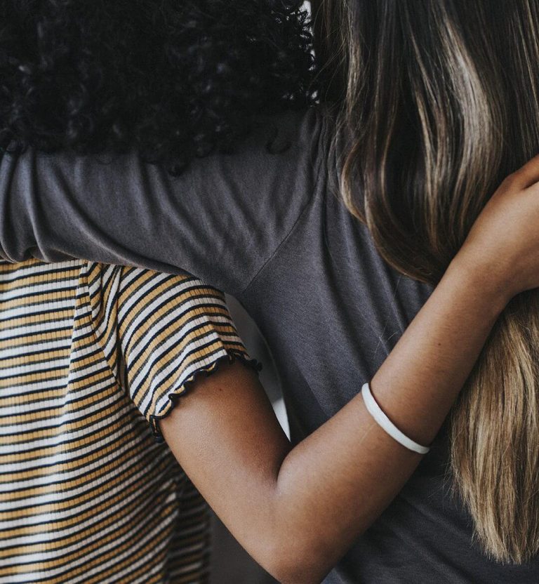 Rearview of diverse people hugging each other