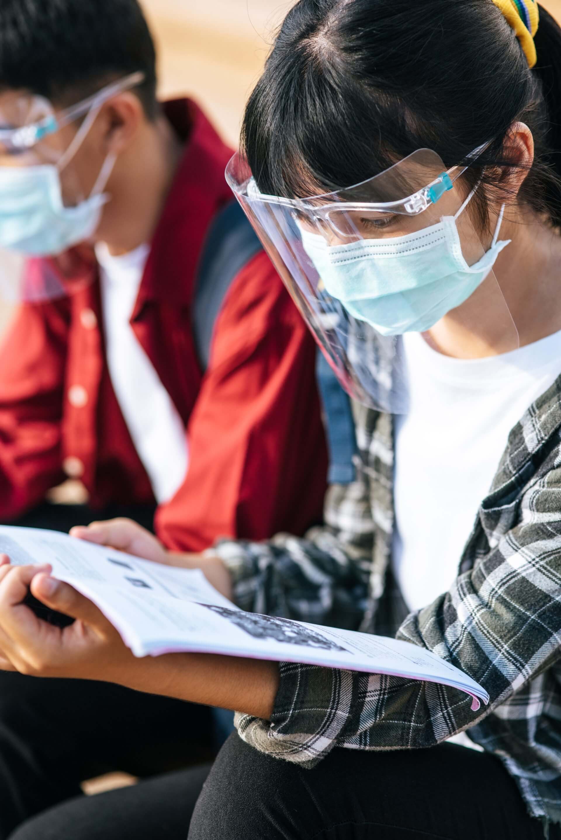male-and-female-students-wearing-masks-sit-and-rea-2025-01-16-13-56-53-utc