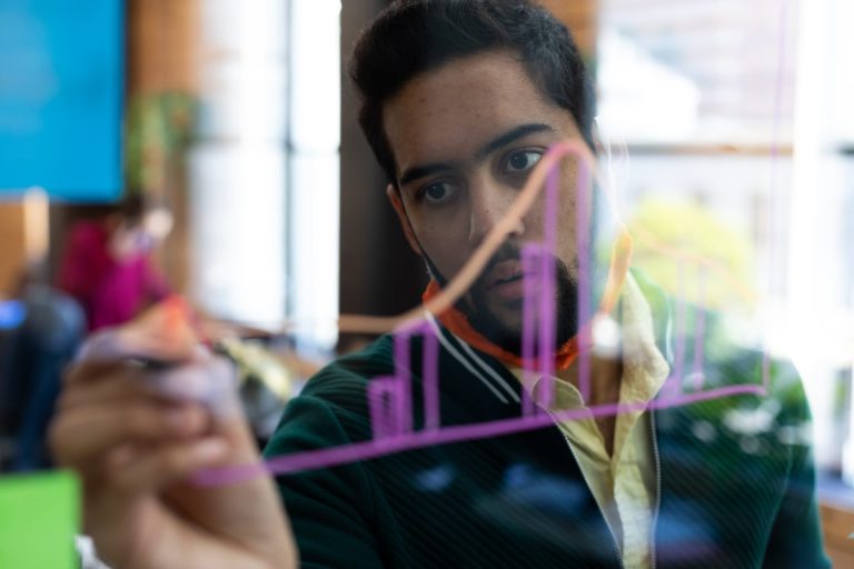 Man draws chart on glass window.