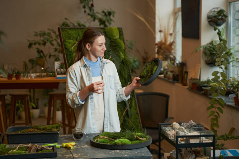Smiling woman holding picture with tropical green plants