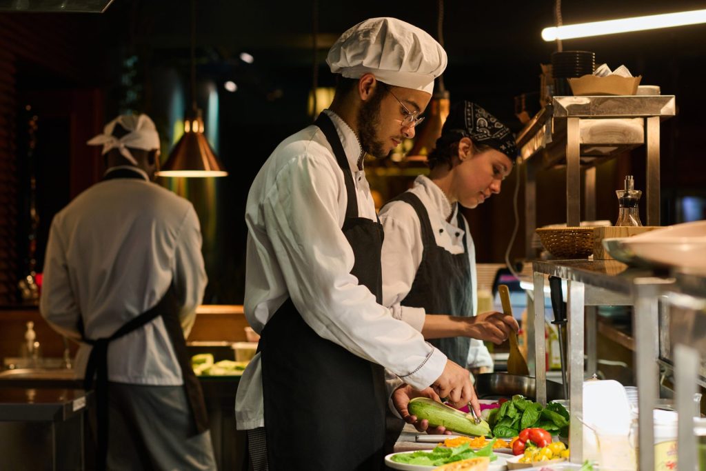 young-multiethnic-male-chef-peeling-fresh-zucchini-2025-02-11-15-38-48-utc