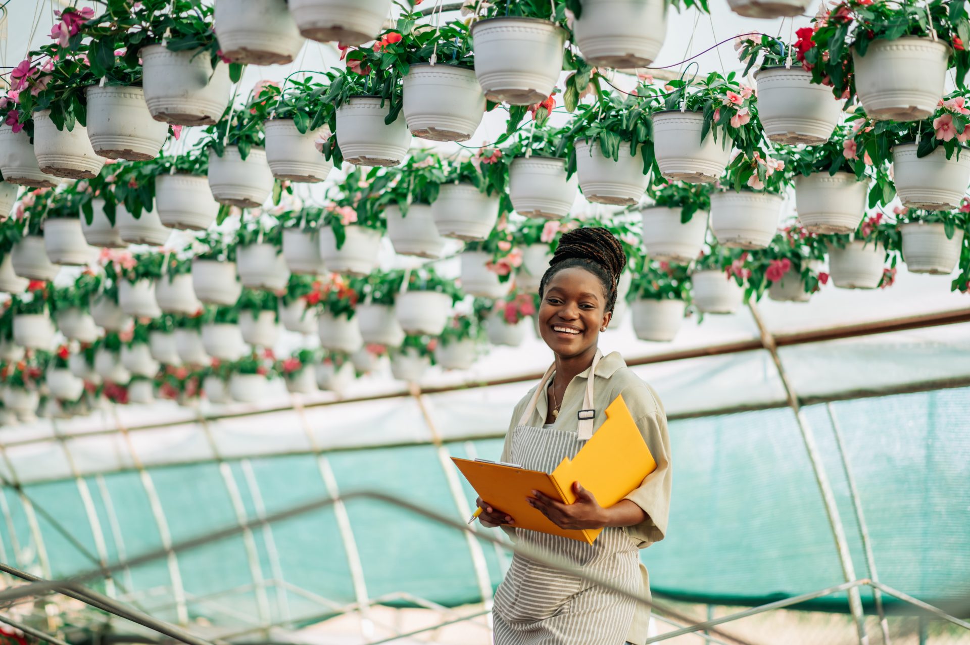 african-woman-working-in-a-greenhouse-flower-plant-2025-04-01-13-23-55-utc