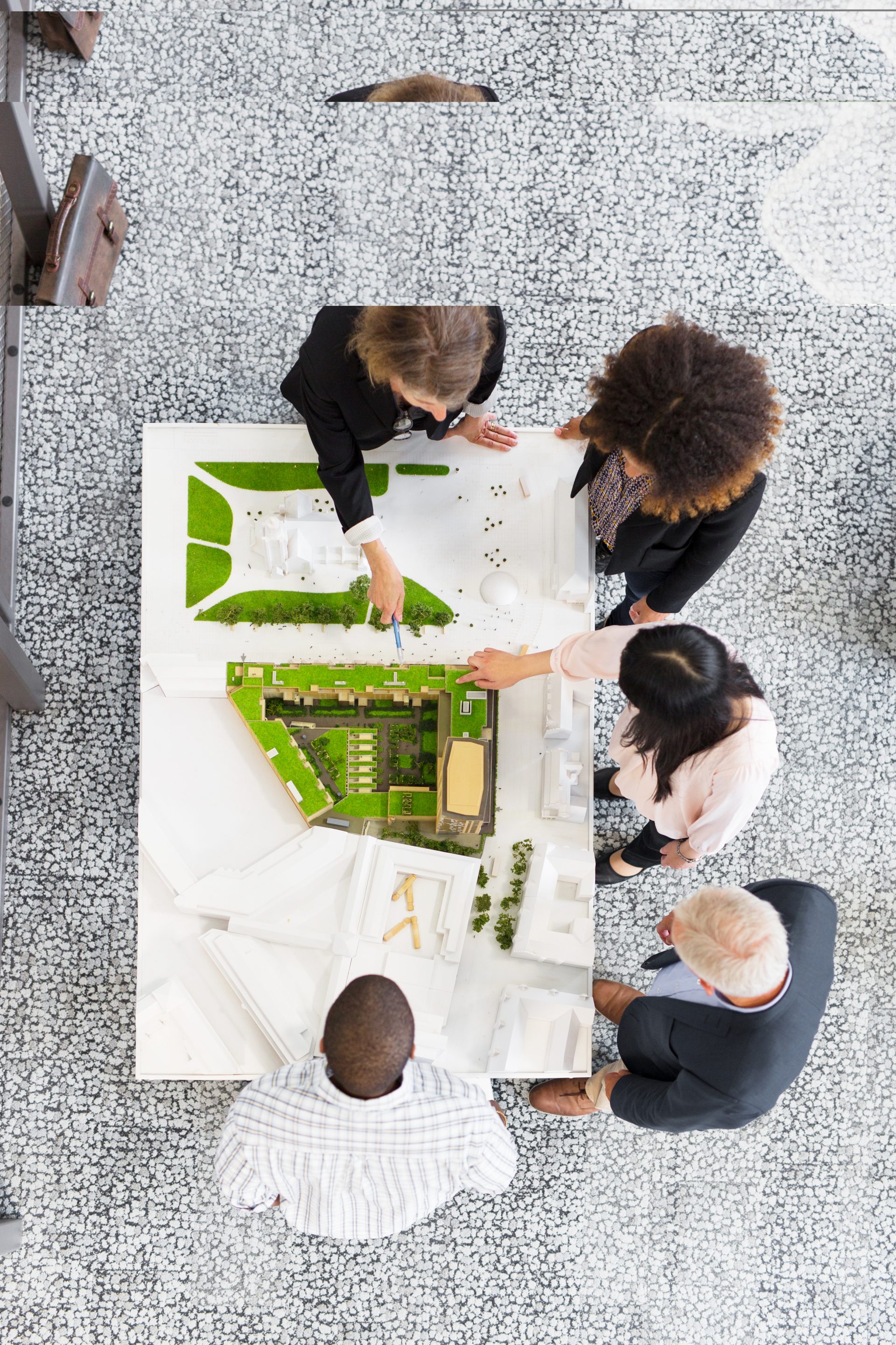 overhead-view-of-architects-discussing-blueprint-2024-10-18-03-54-20-utc