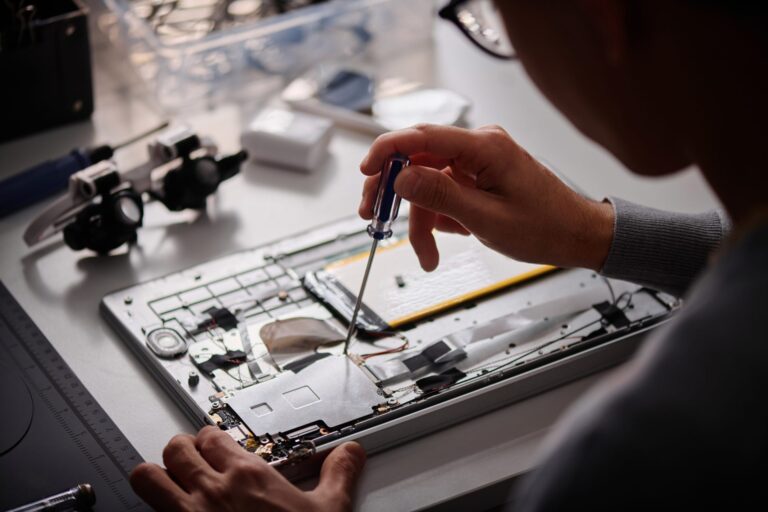 young-repairman-fixing-laptop-element-in-his-works