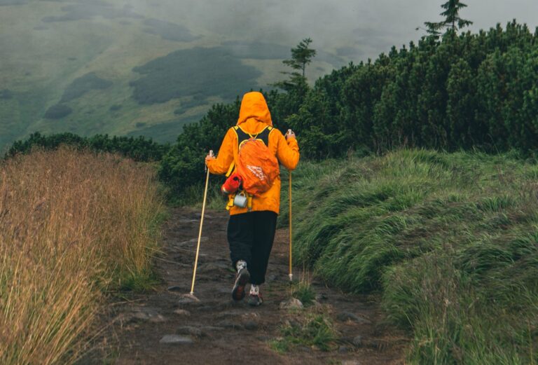 woman-in-yellow-raincoat-at-mountain-trail-road