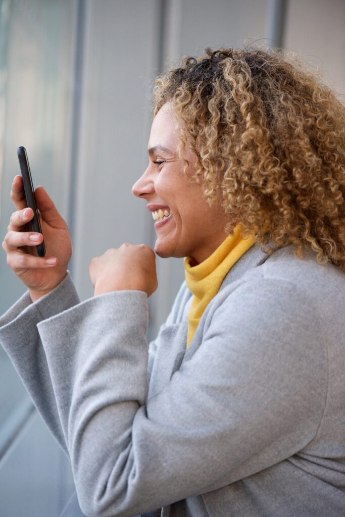 Woman-holding-phone_yellow-sweater