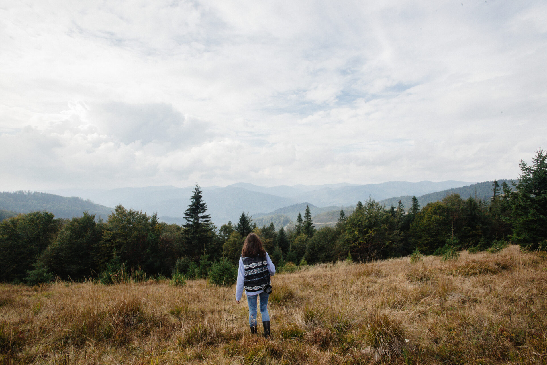 happy stylish traveling girl  in the mountains on a ba